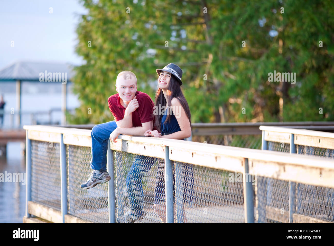 Young interracial couple standing together on wooden pier overlo Stock Photo