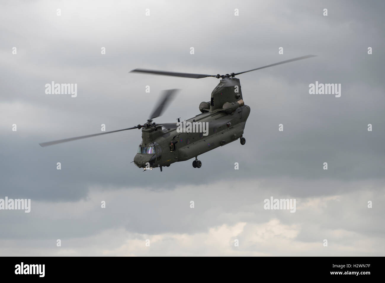 Loadmaster of a British Royal Air Force Boeing Chinook CH-47D Helicopter waves from his station as it demonstrates at the RIAT Stock Photo