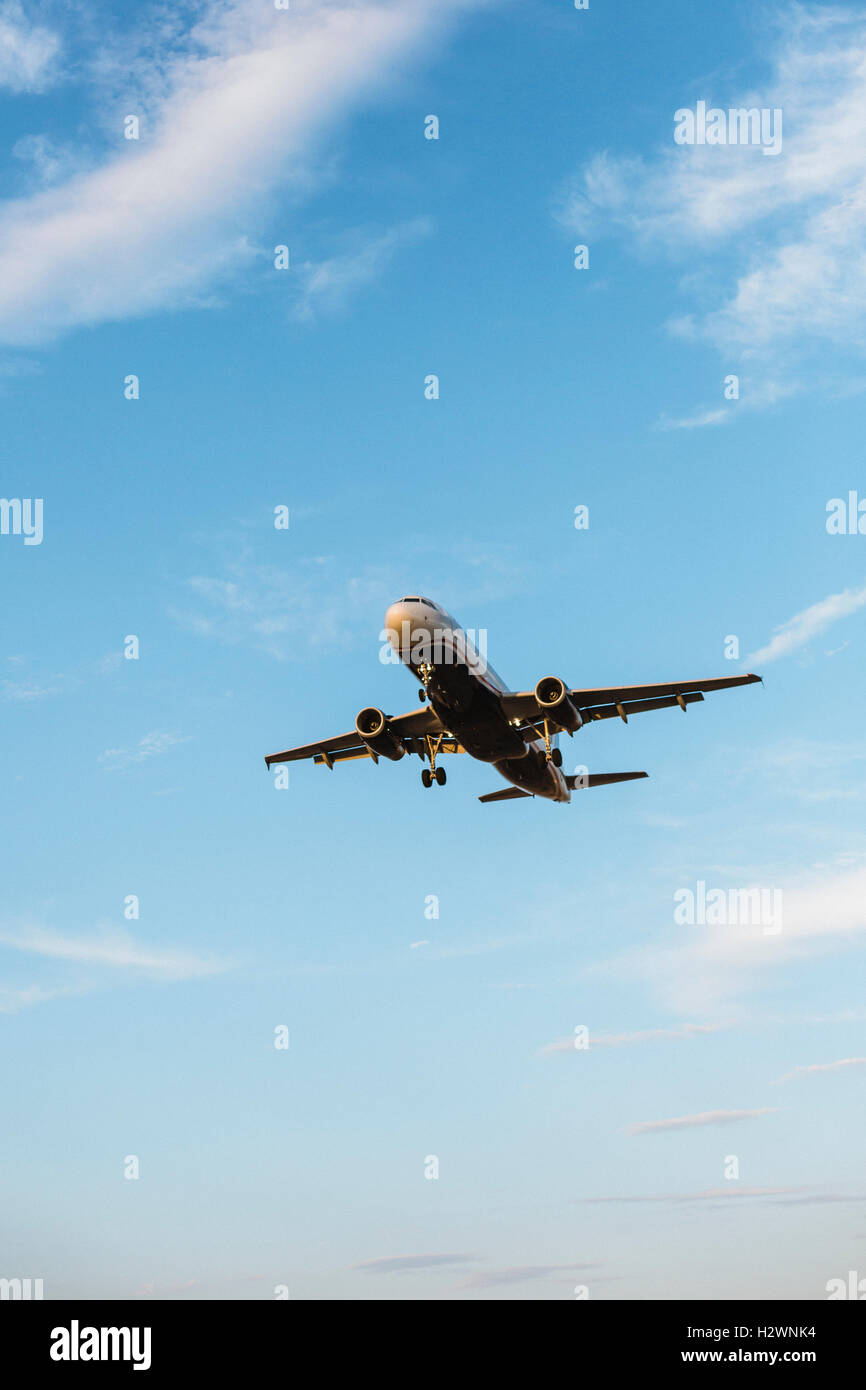 Airplane flying with blue sky in background Stock Photo - Alamy
