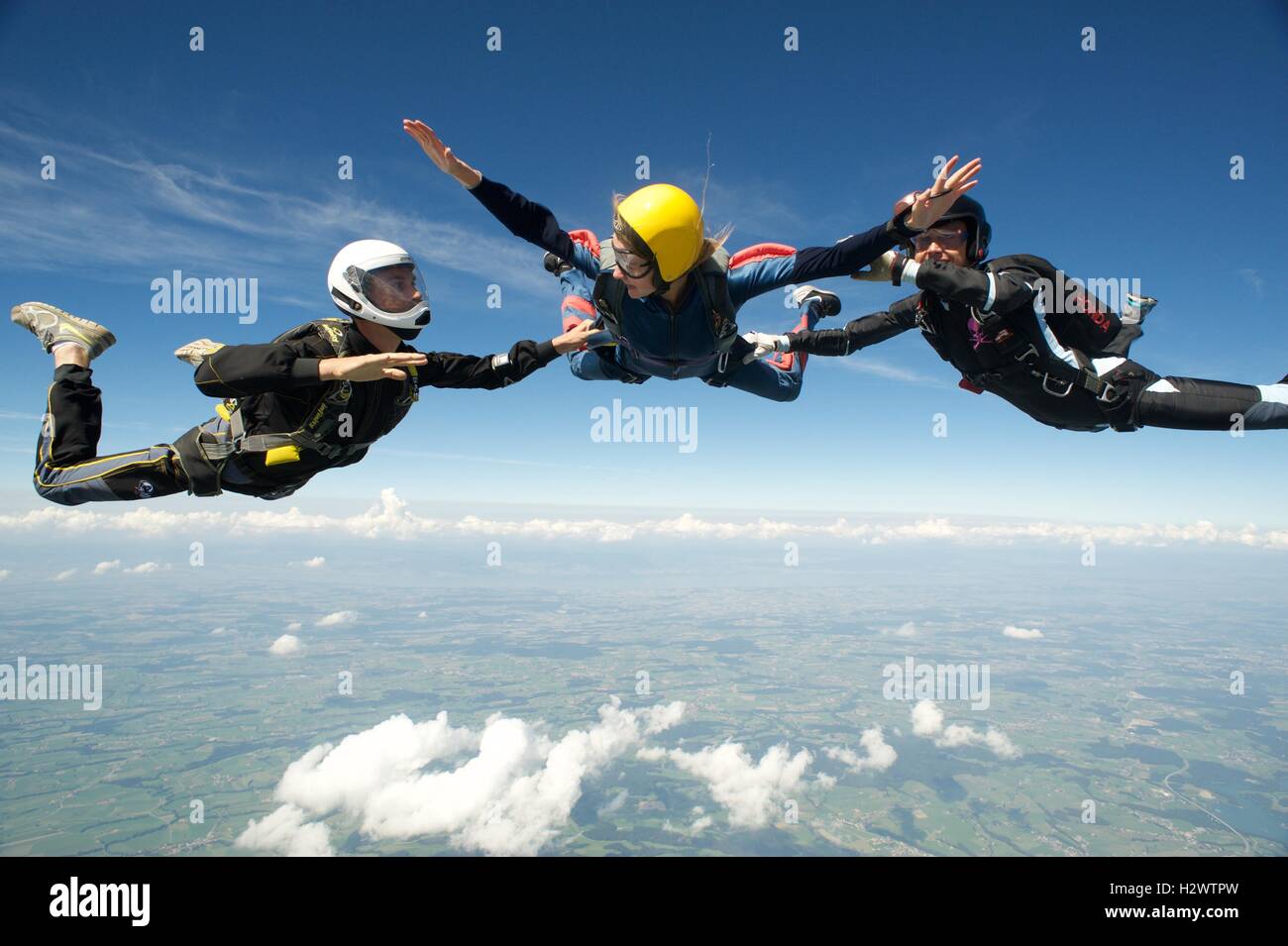 Woman on her first freefall jump with two instructors Stock Photo