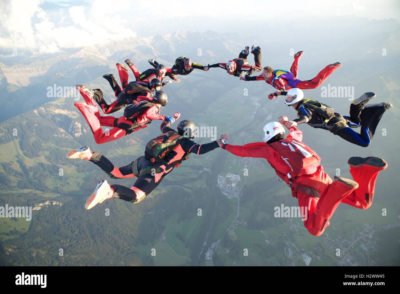 Nine skydivers form a star formation over Gruyères in Switzerland Stock Photo