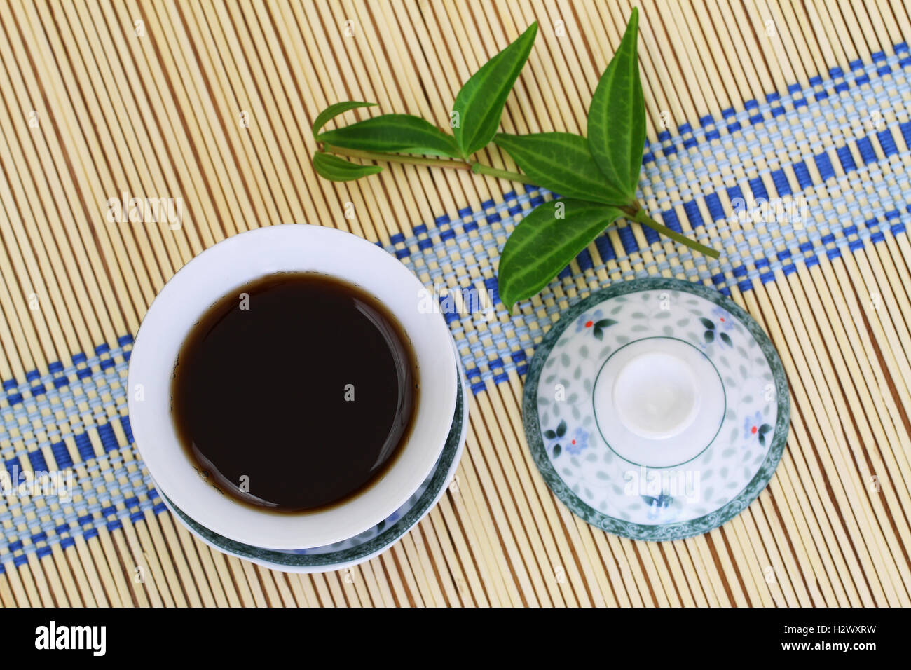 Strong tea in oriental cup on bamboo mat Stock Photo