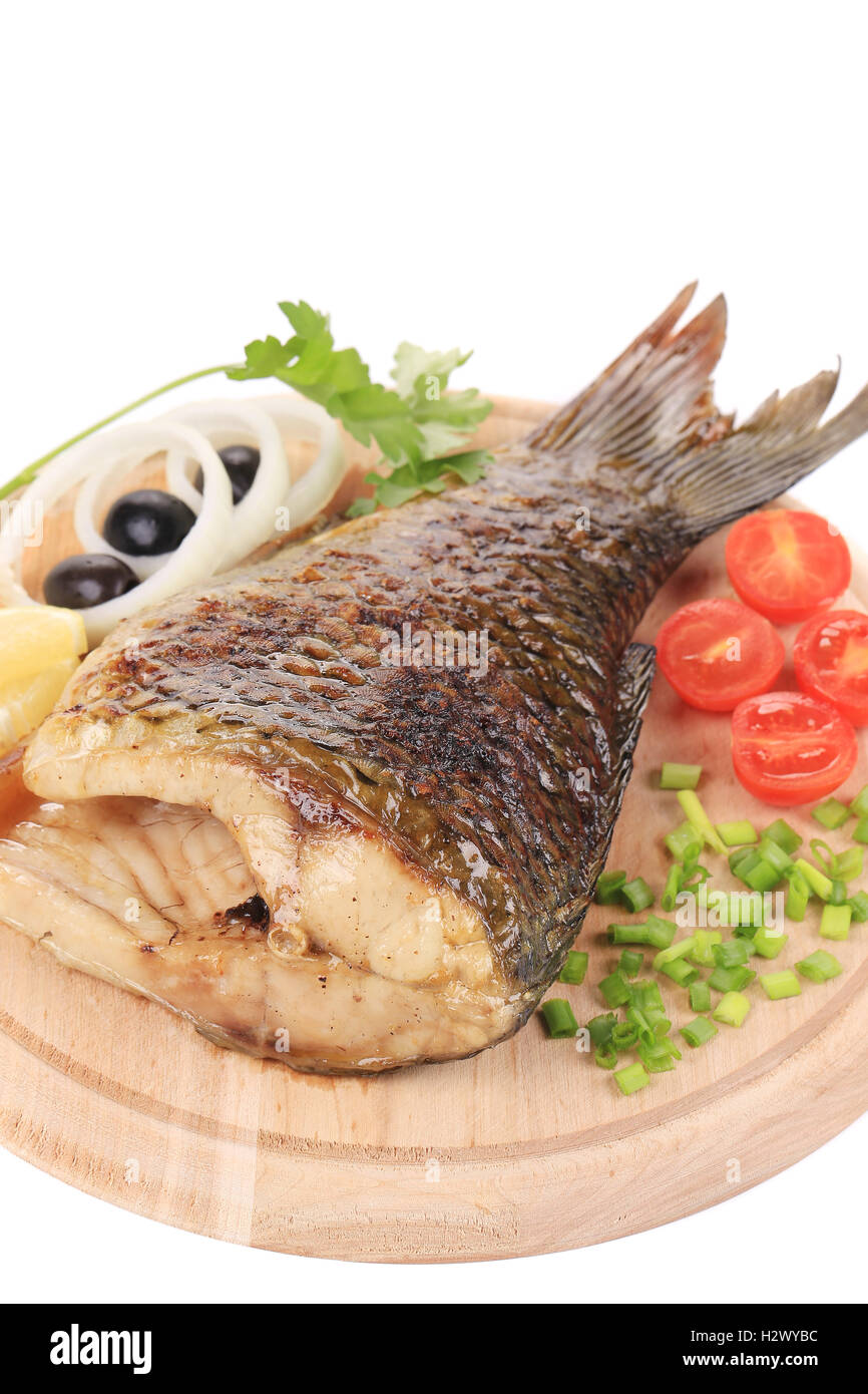 Fried carp on wooden platter. Stock Photo