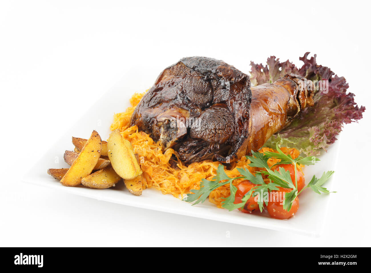 Fried pork knuckle with potatoes and tomato Stock Photo