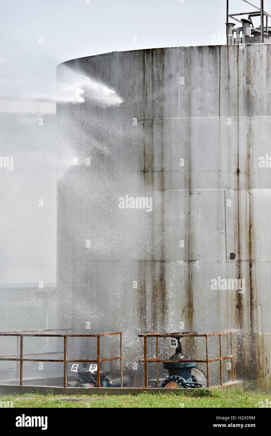 Firefighter water jet extinguish the fire started near a petrol storage tank Stock Photo Alamy