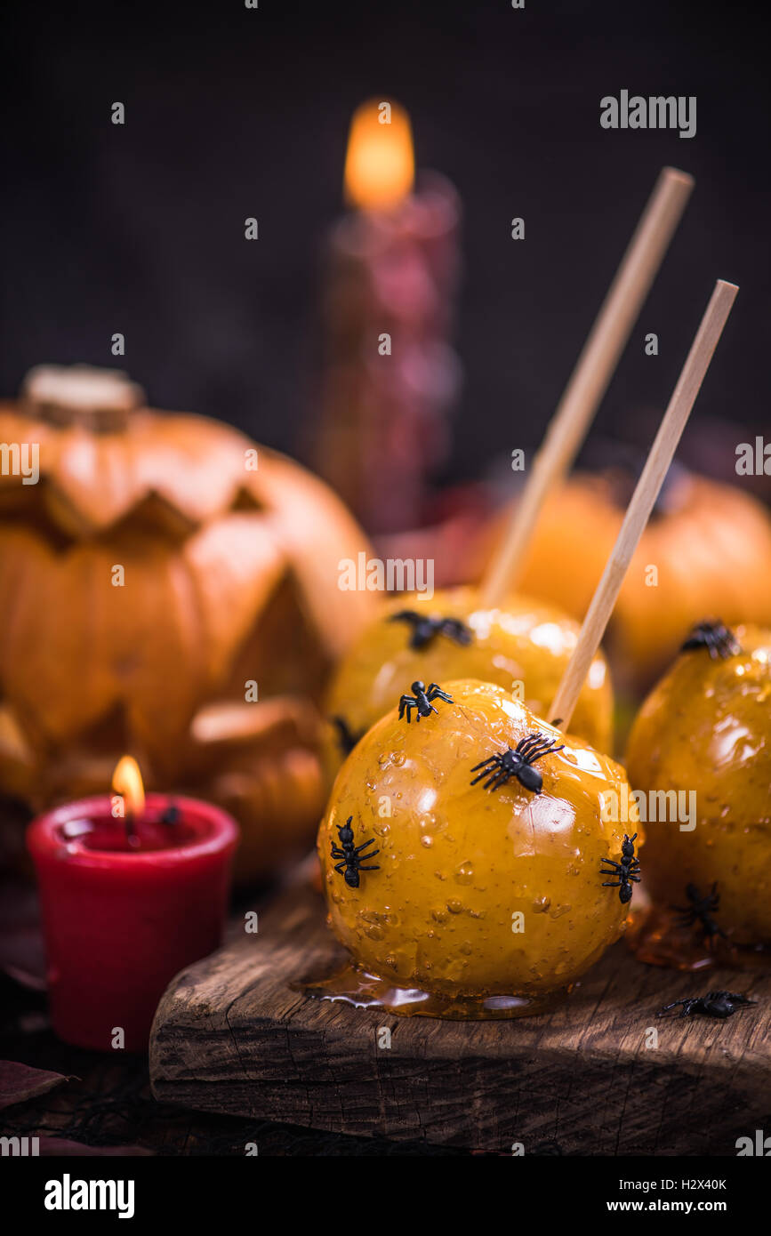 Spooky party Halloween food, apple candy with spiders and worms Stock Photo