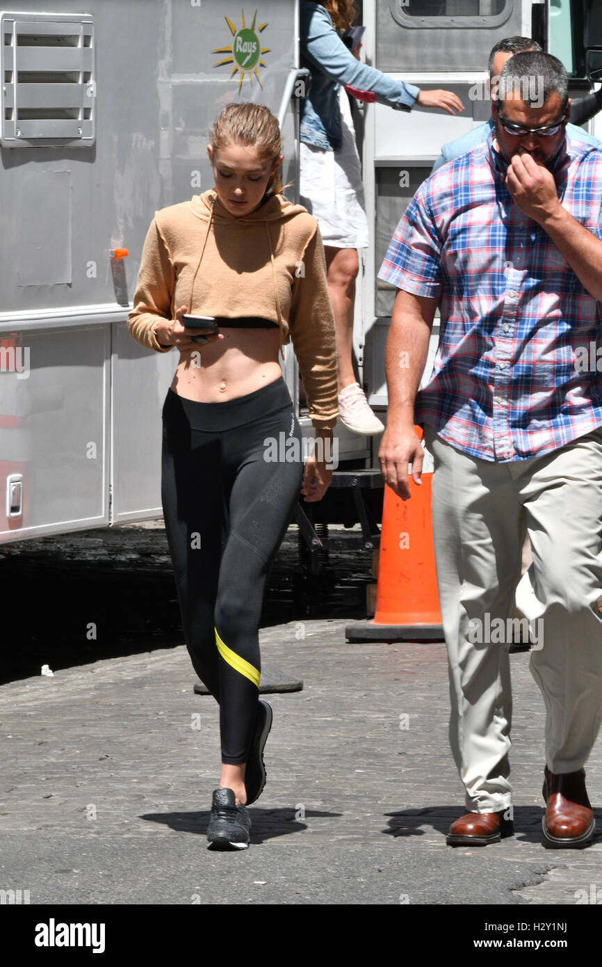 Gigi Hadid returning to her apartment as a photographer takes a tumble