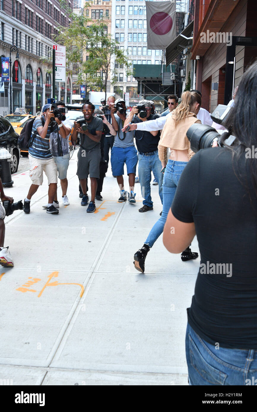 Gigi Hadid returning to her apartment as a photographer takes a tumble