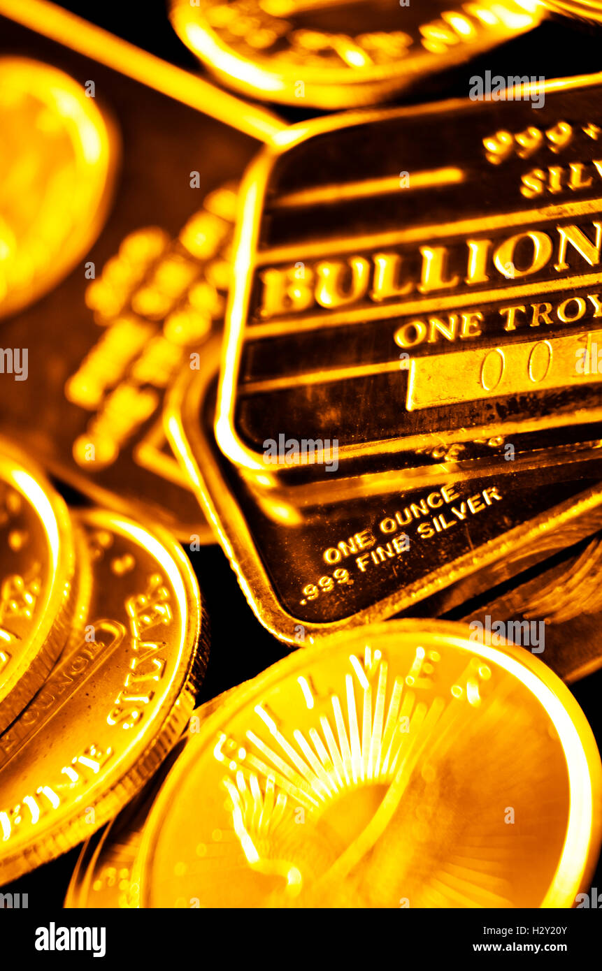 Several stacks of gold coins and bars representing wealth Stock Photo