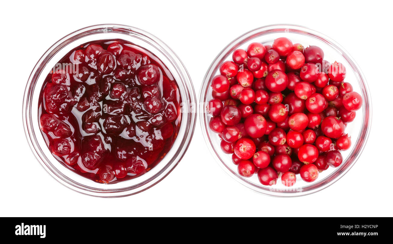 Lingonberry jam and lingonberries in glass bowls over white. Fresh red fruits of Vaccinium vitis-idaea, also mountain cranberry. Stock Photo