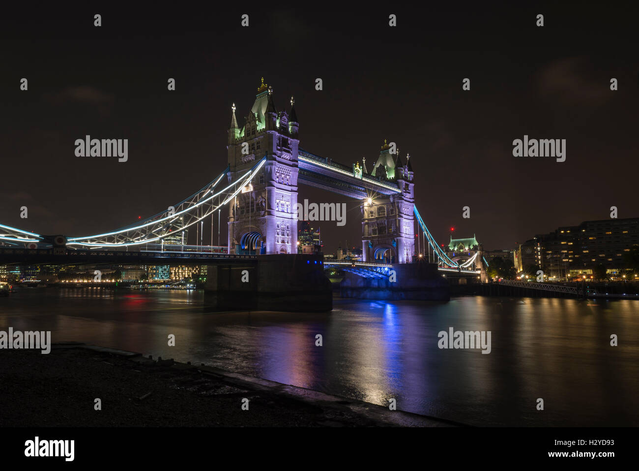 Tower Bridge over the River Thames at night viewed from Butler's Wharf, London, UK Stock Photo