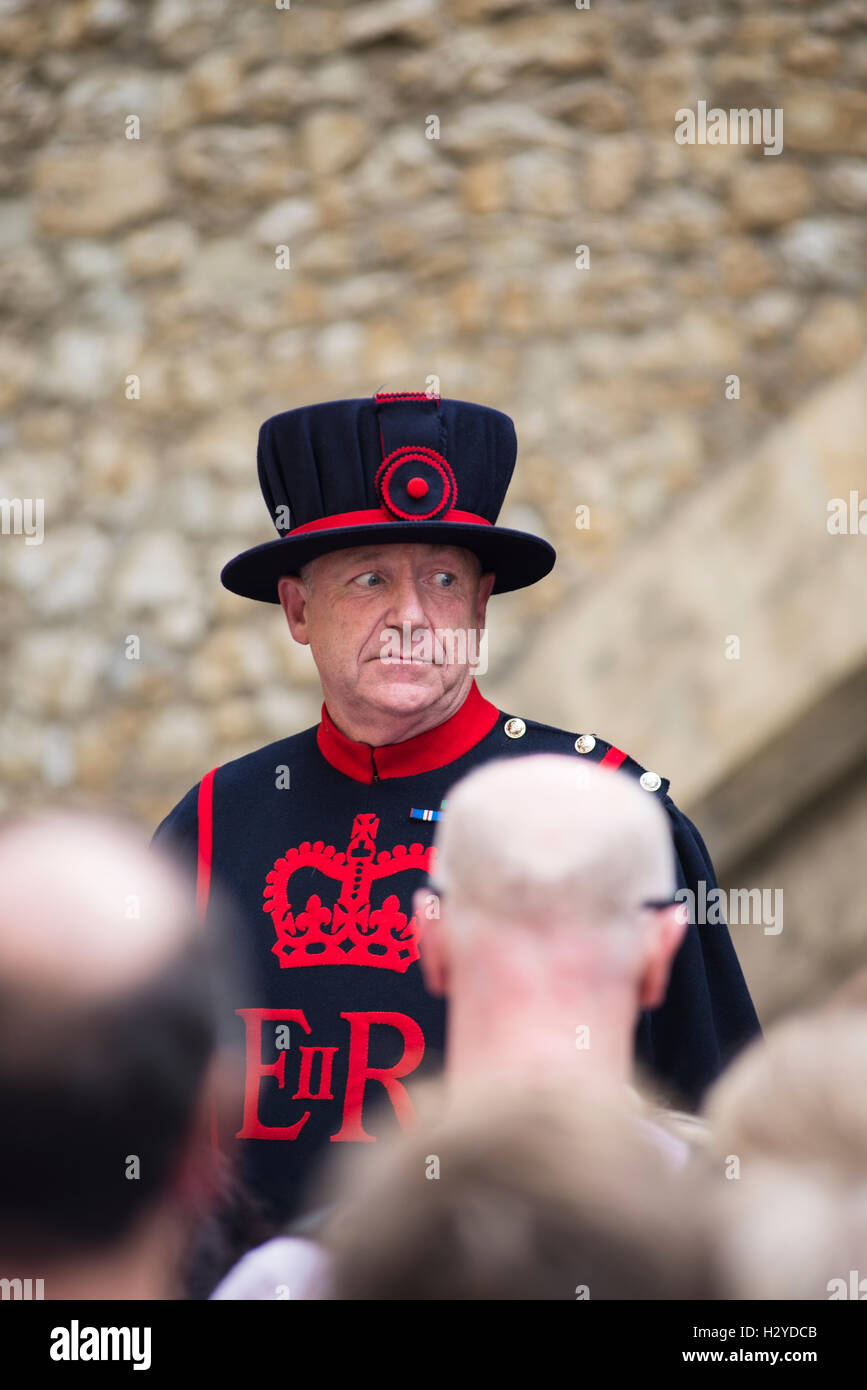 Yeoman Warder Guardsman staring at tourist on a guided tour at the Tower of London, London,UK Stock Photo