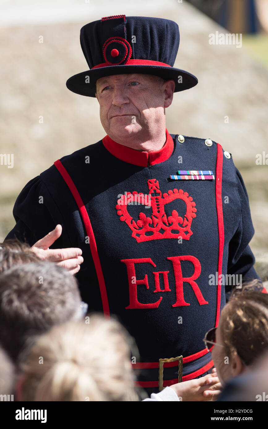 Yeoman Warder Guardsman in uniform with royal emblems on a guided tour at the Tower of London, London,UK Stock Photo