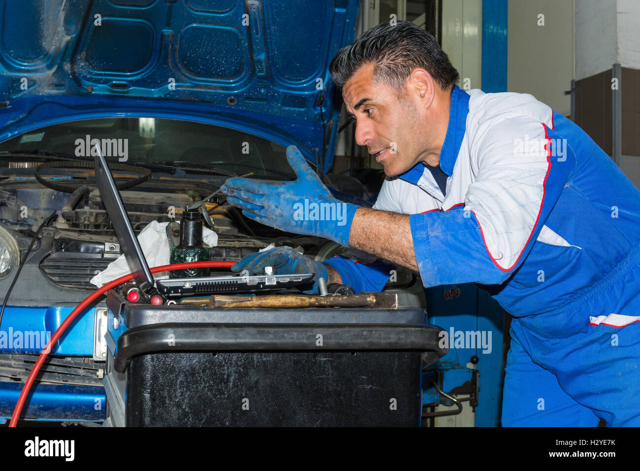 Car mechanic fixing an engine in his garage. copy space Stock Photo Alamy