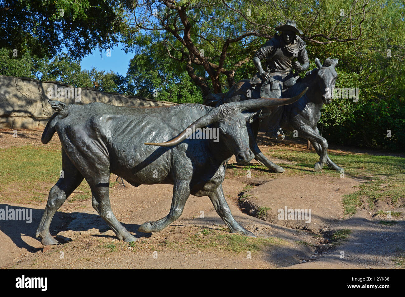 Bronze statues of a bull and cowboy on horseback, part of an old west cattle drive in Pioneer Plaza, downtown Dallas, Texas. Stock Photo