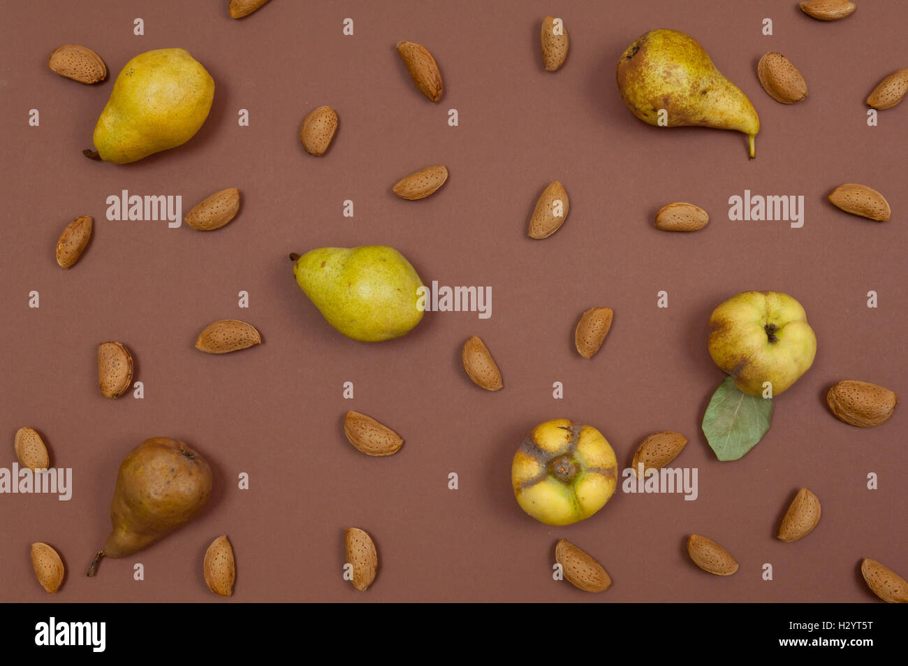Autumn fruits and nuts on brown background Stock Photo