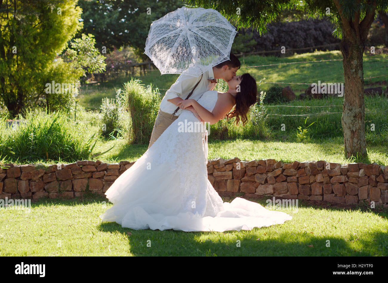 Bride and groom kissing in garden wedding Stock Photo - Alamy