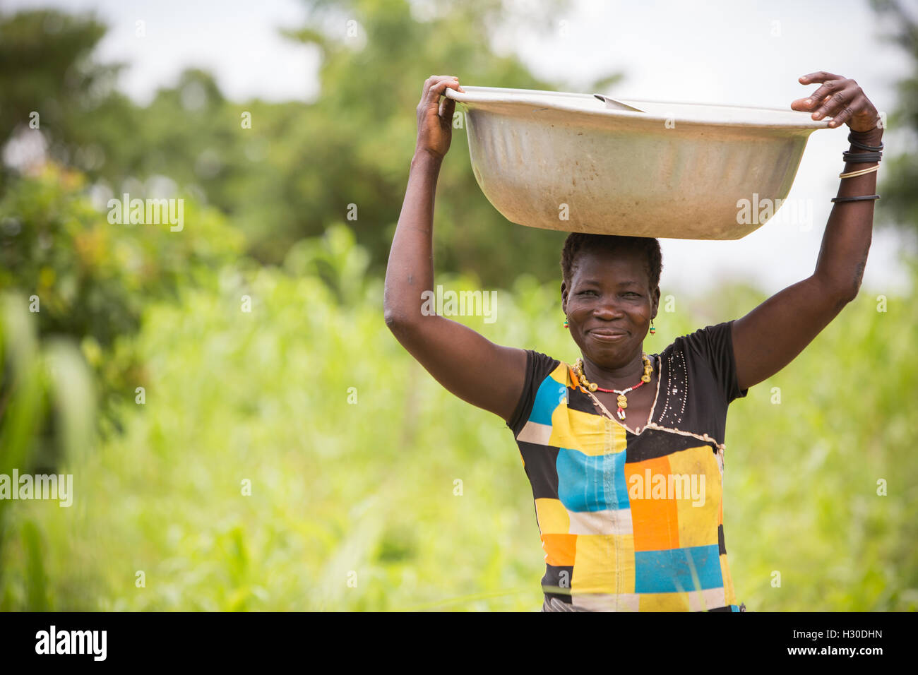A woman carries a basin on her head in rural Réo department, Burkina Faso, West Africa. Stock Photo