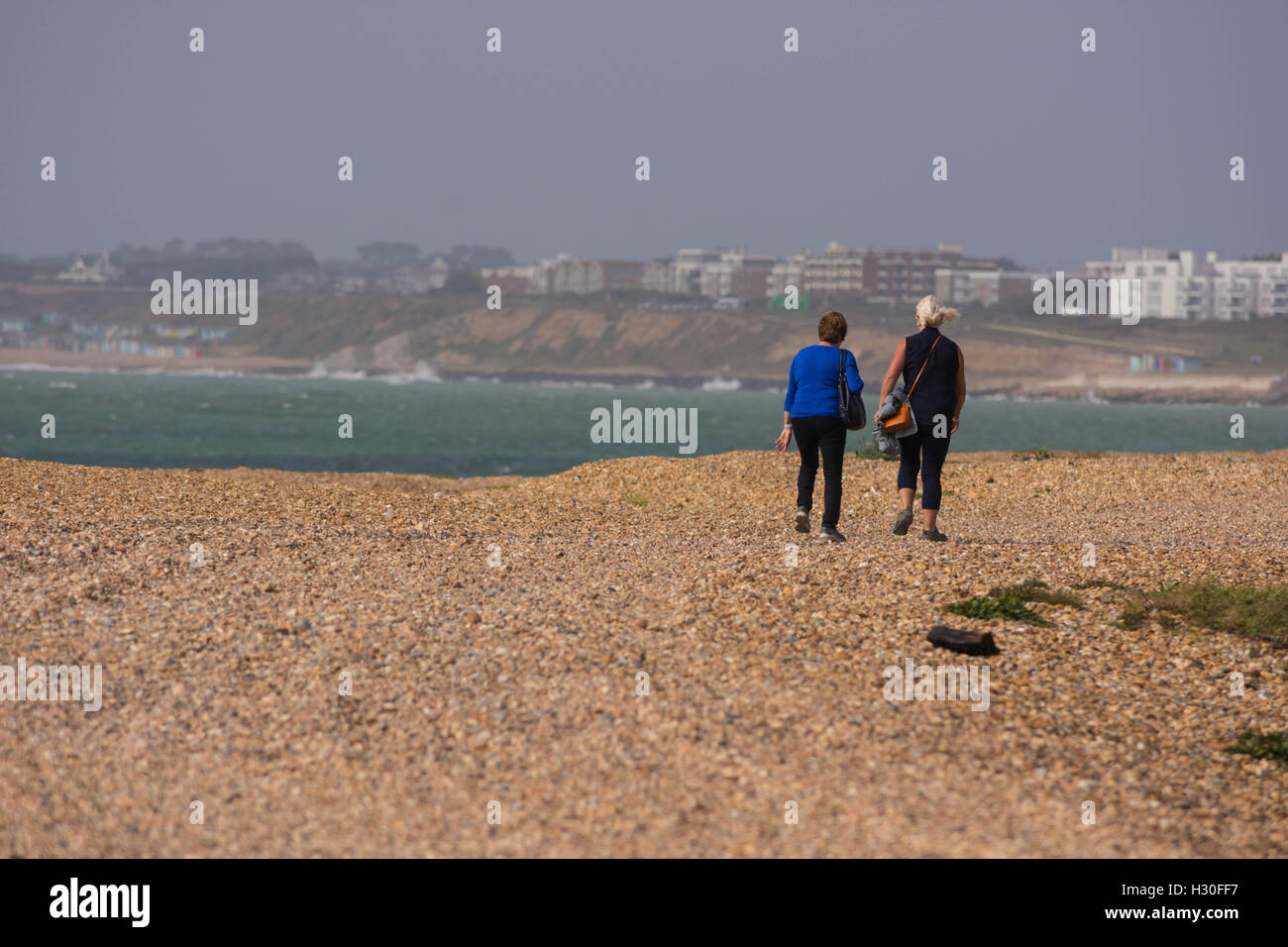 Two elderly women walking together on a beach. Stock Photo