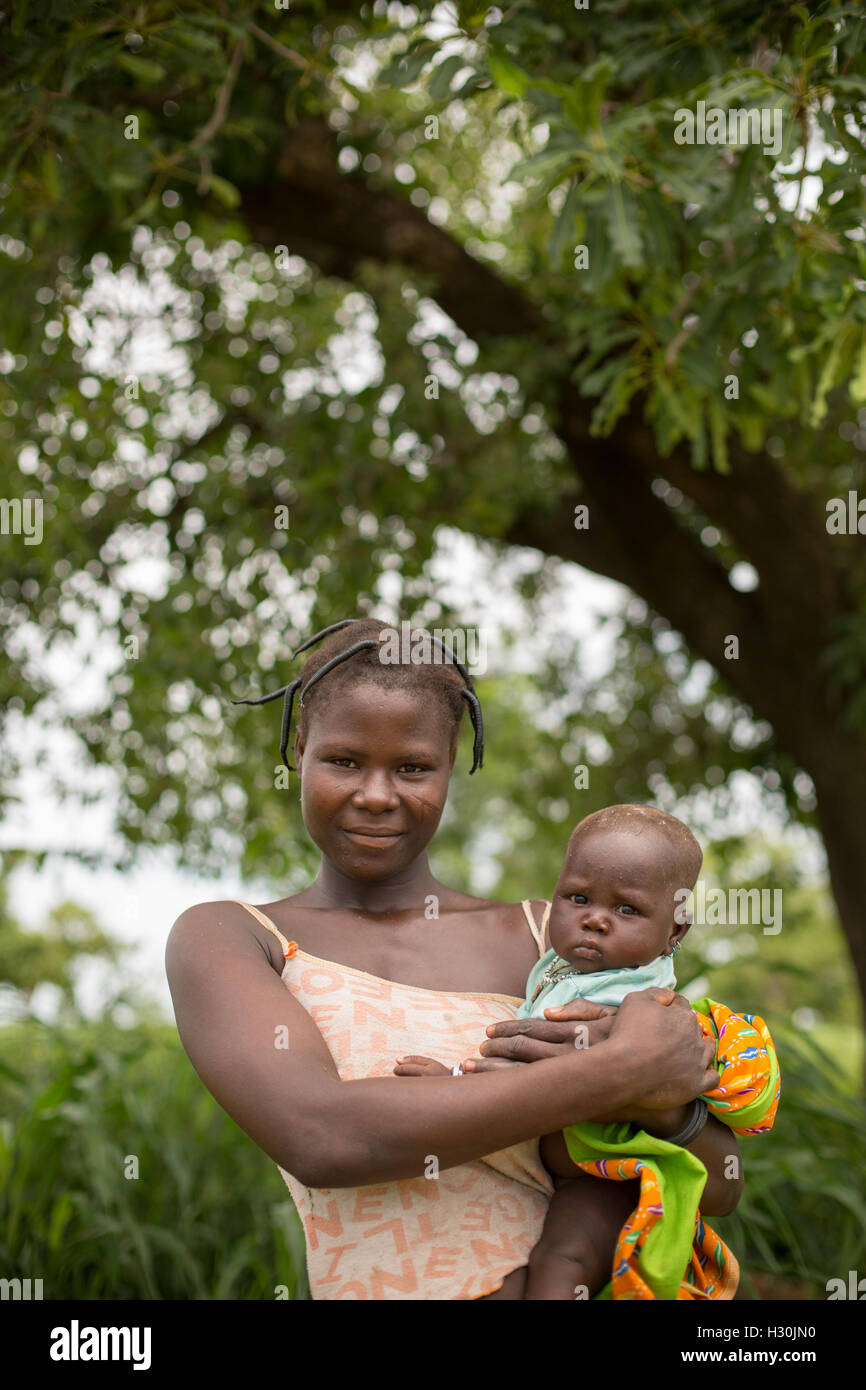 A mother and child stand beneath a shea tree in Réo Department, Burkina Faso, West Africa. Stock Photo