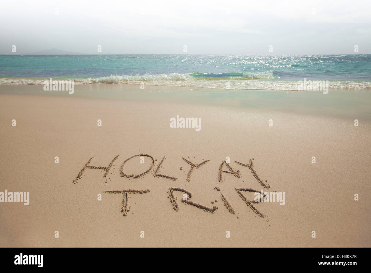 Holiday trip handwriting on tropical sea beach Stock Photo