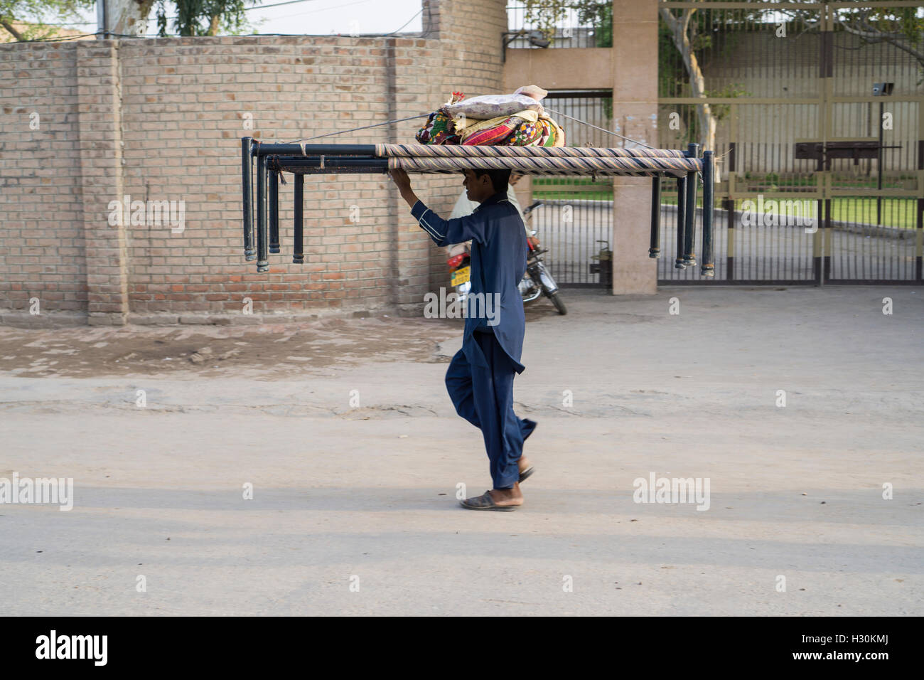 Man carrying two beds on his head Stock Photo