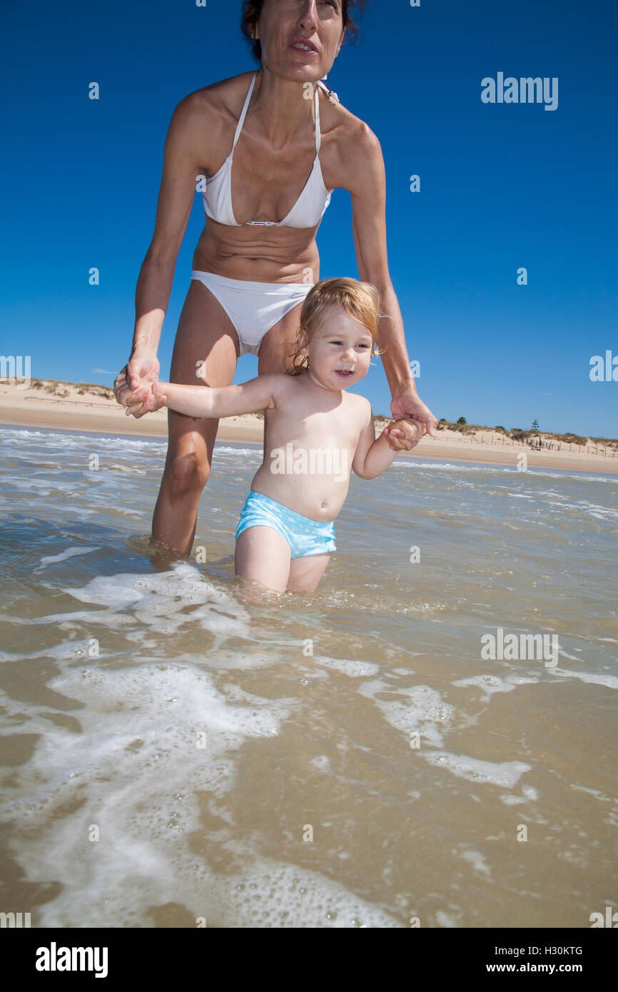 summer happy family of two years blonde baby with blue swimsuit