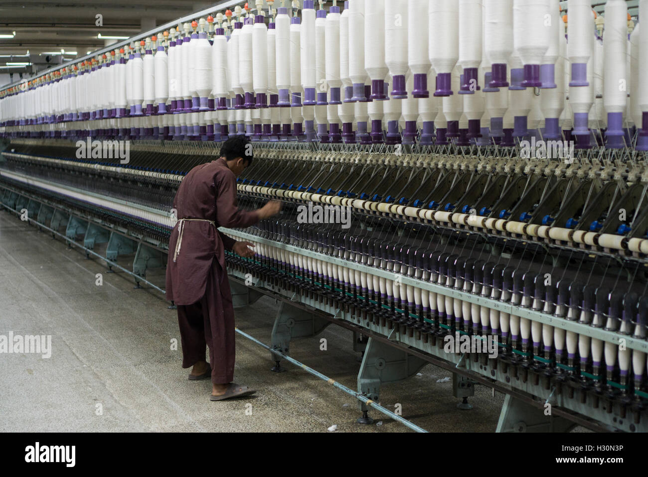 Man operating cotton spinning machine Multan Pakistan Stock Photo