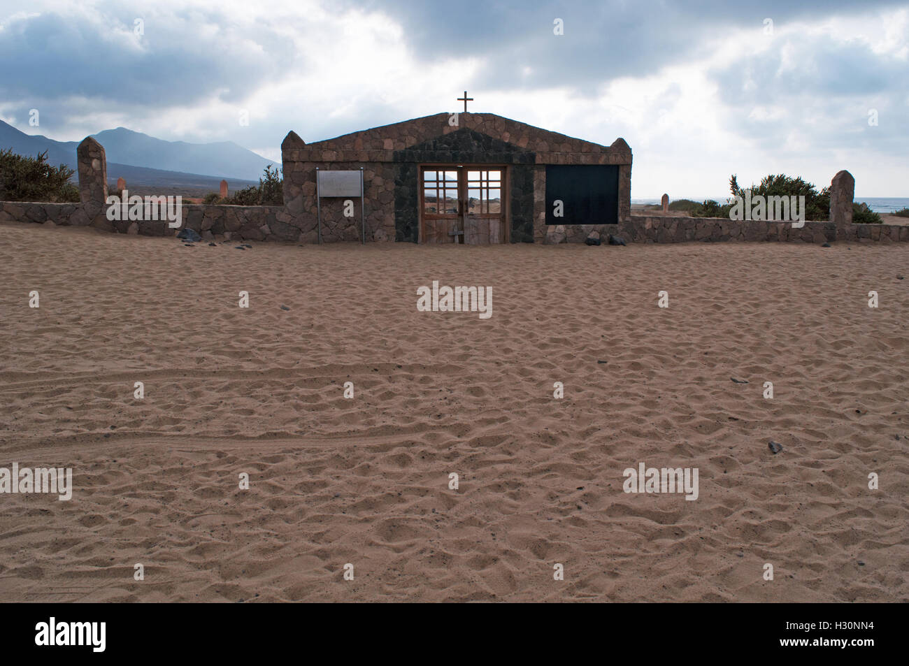 Fuerteventura: cloudy day and the gate of the marine cemetery on the beach of Playa de Cofete, where are buried locals, vagabonds and drowning victims Stock Photo