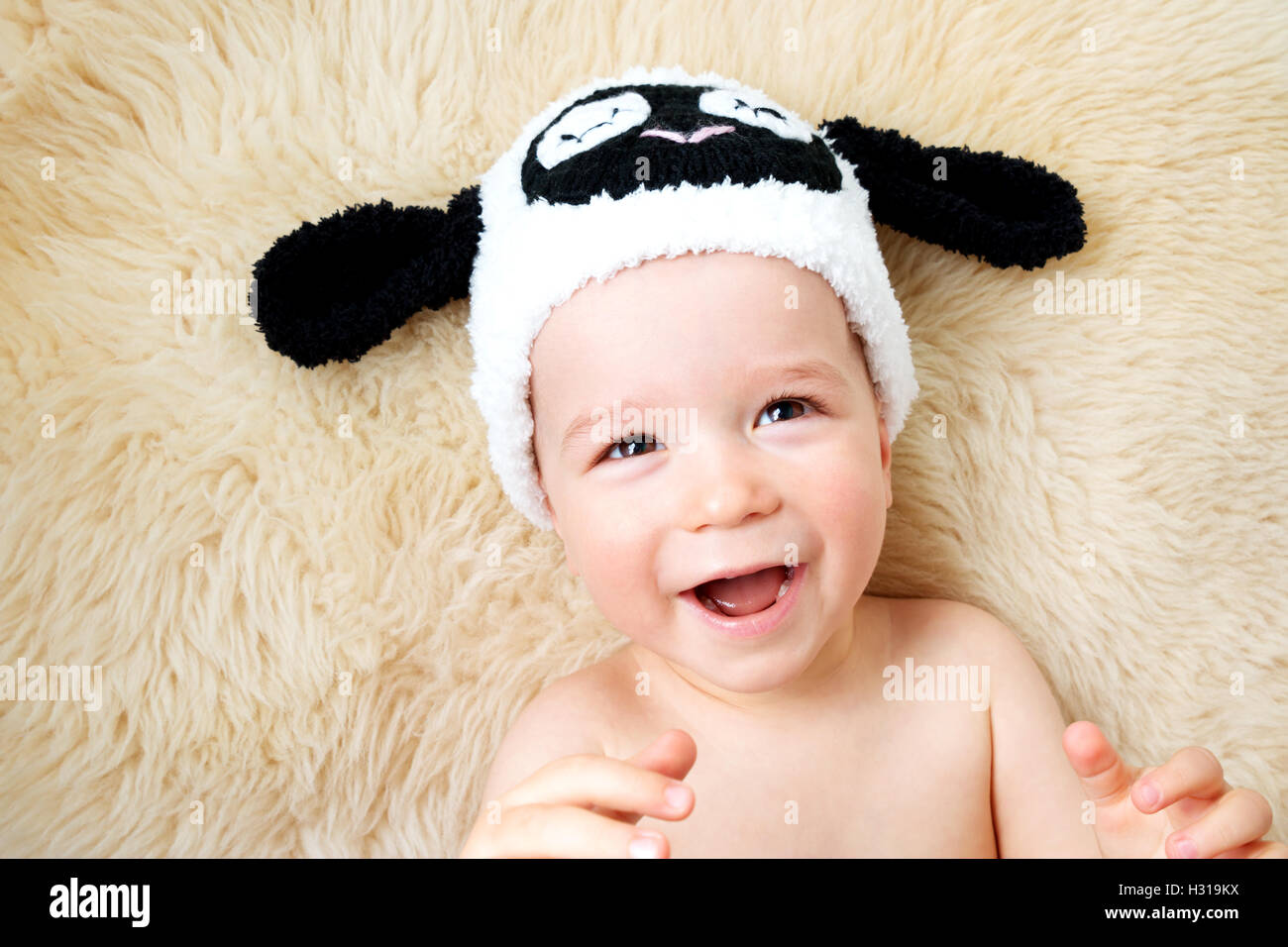 one year old baby lying in sheep hat on lamb wool Stock Photo Alamy
