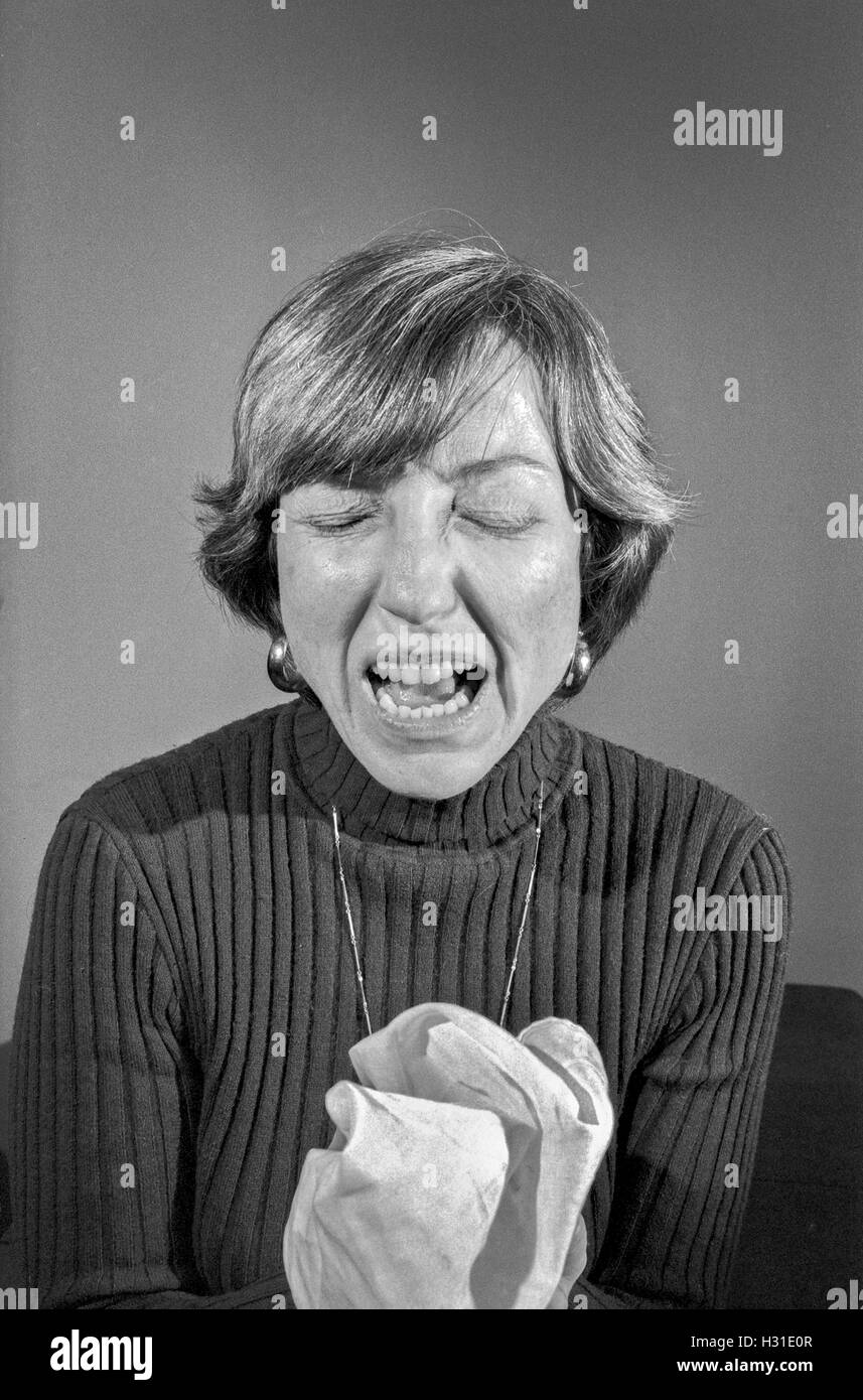 An adult woman sneezes. MODEL RELEASE Stock Photo