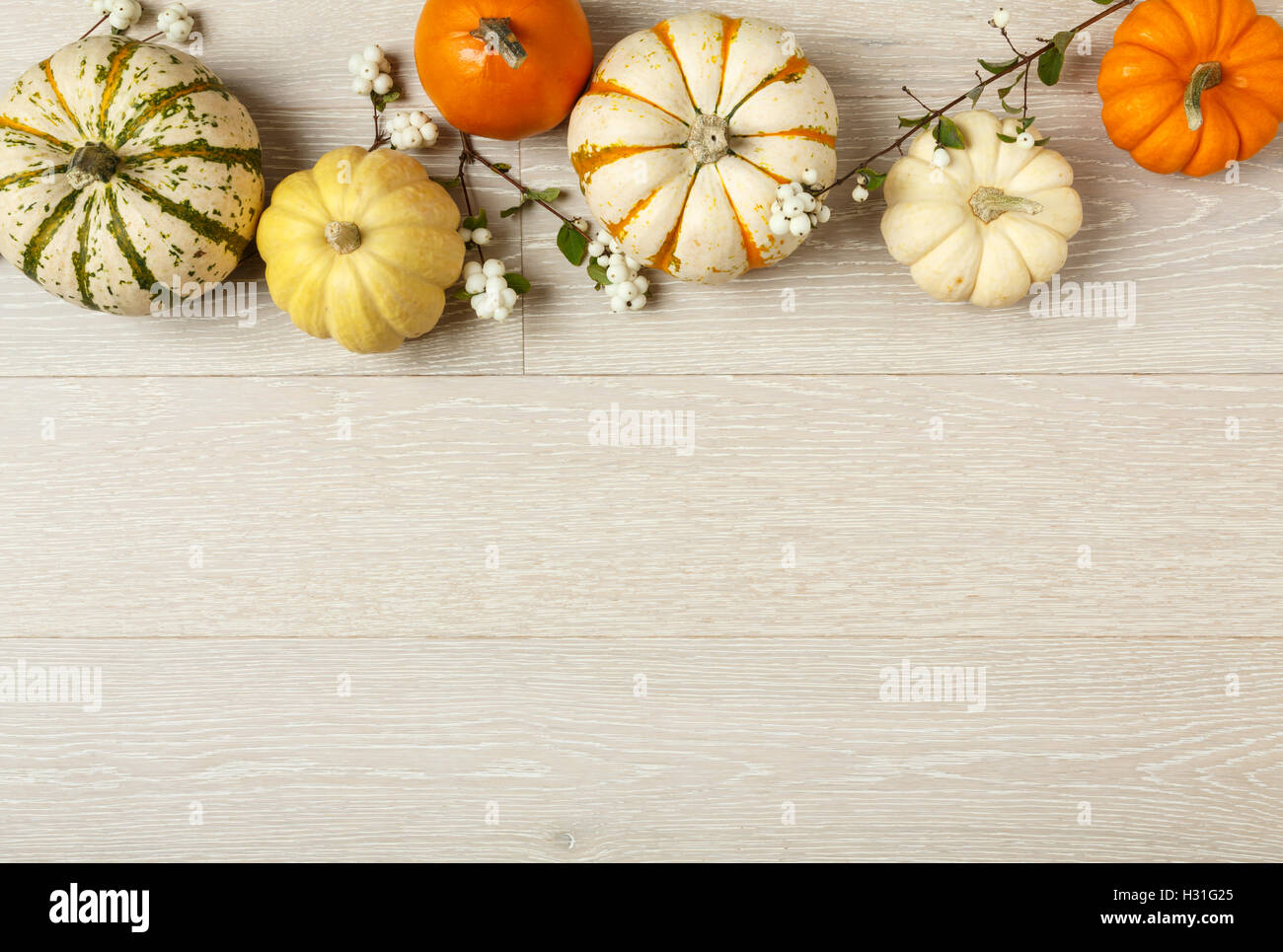 Miniature pumpkins on rustic wood background. Simple, natural country style fall autumn decorations. Stock Photo