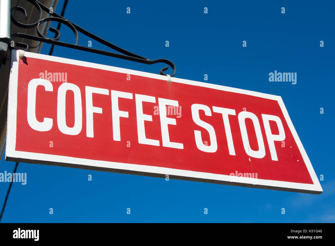 Coffee Stop sign white lettering on painted red background with blue sky backdrop NSW Australia Stock Photo
