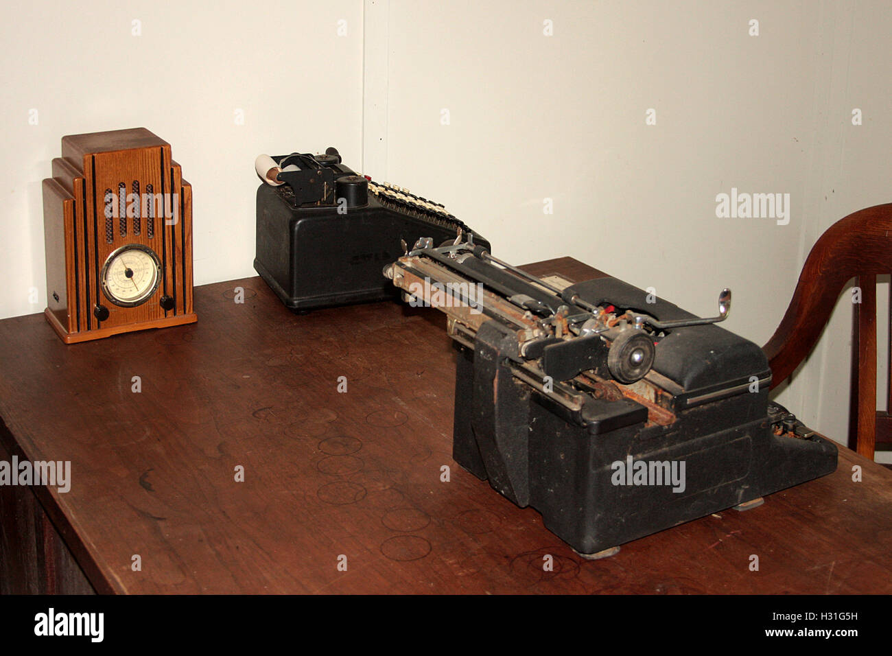 Old typewriters and small antique clock on desk Stock Photo