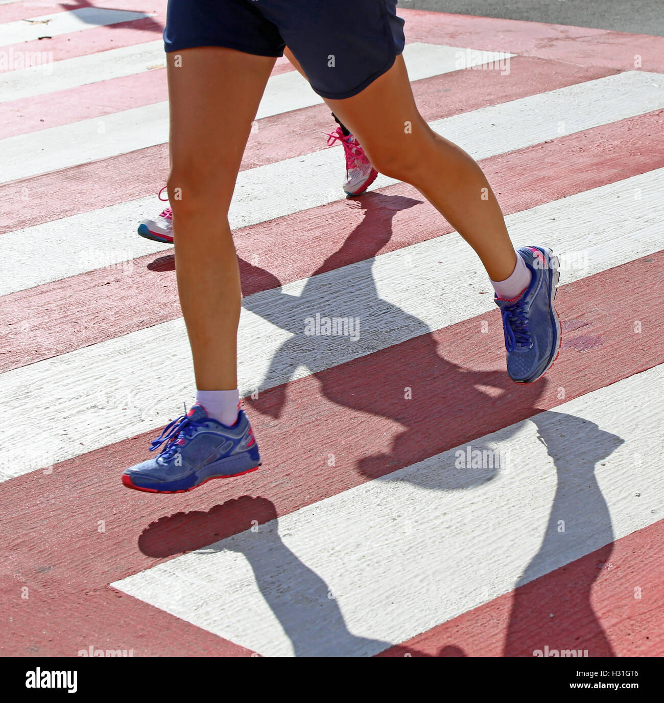 fast runners during a marathon race on a pedestrian crossing with red