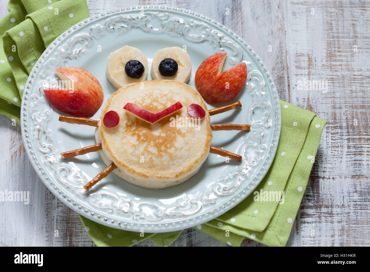 Funny breakfast for child. Pancake crab with apple. Stock Photo