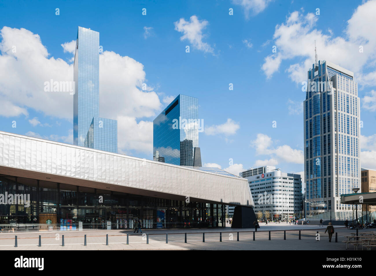 View of lateral entrance to station showing metal clad roof and high rise buildings on the background. Centraal Station, Rotterdam, Netherlands. Architect: Benthem Crouwel Architects + MVSA Architects + Wes, 2014. Stock Photo