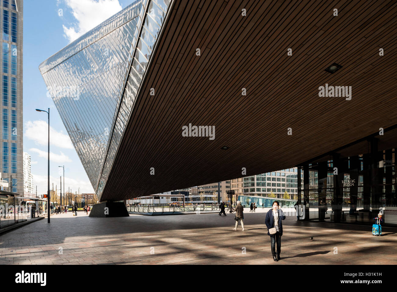 Passengers crossing the open plaza underneath the metal clad canopy. Centraal Station, Rotterdam, Netherlands. Architect: Benthem Crouwel Architects + MVSA Architects + Wes, 2014. Stock Photo