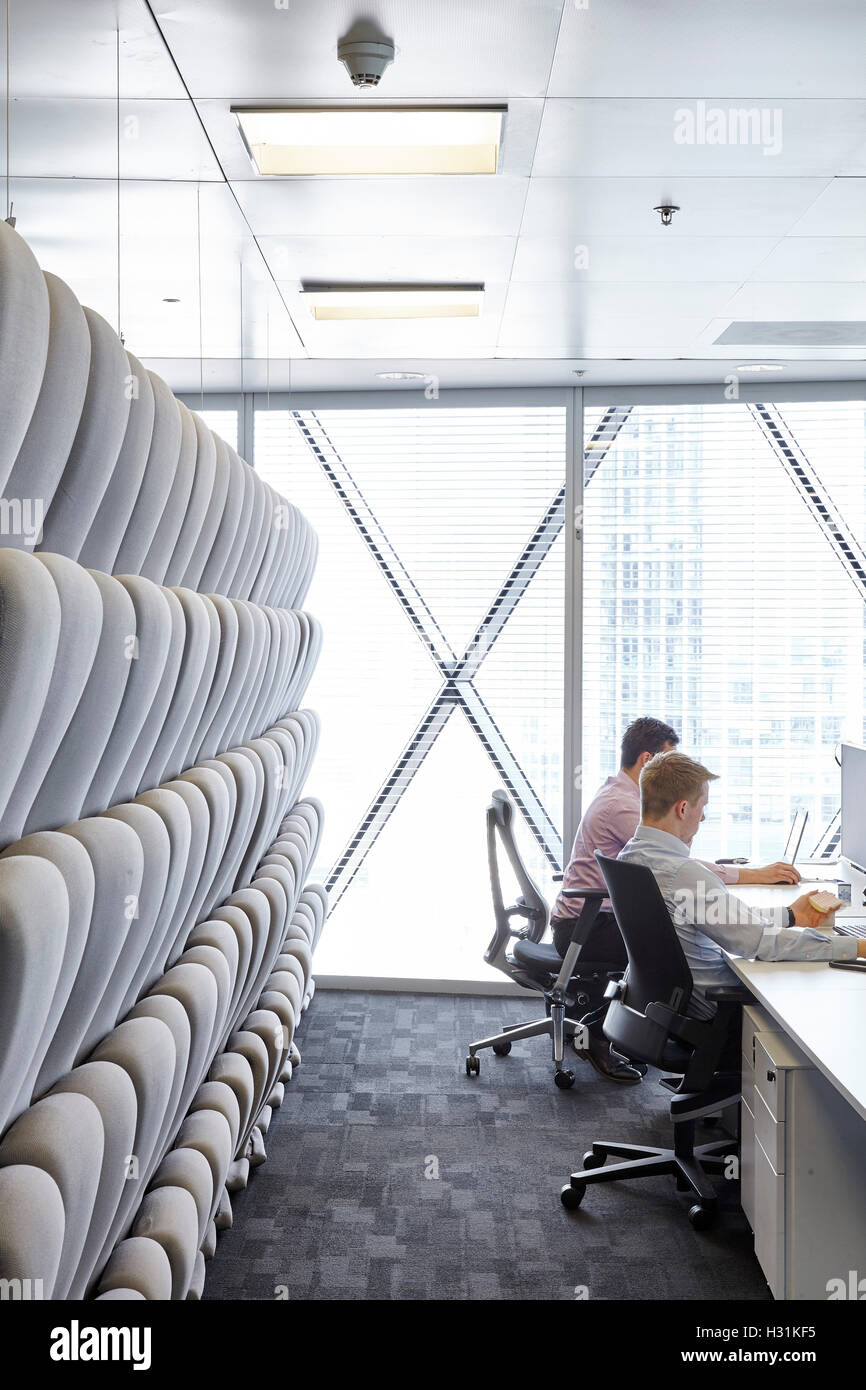 Padded movable sound proof walls and office workers at desks. Office Space at The Gherkin, London, United Kingdom. Architect: IOR GROUP Interiors, Foster + Partners, 2016. Stock Photo