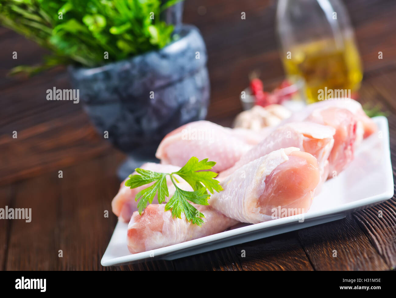 chicken legs on plate and on a table+ Stock Photo - Alamy