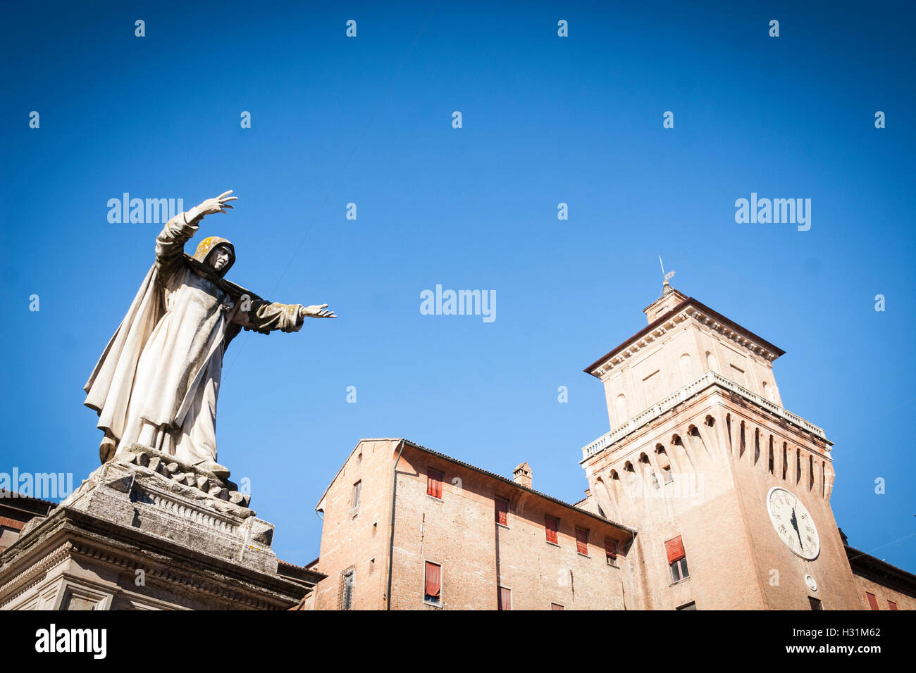 View of Castle Estense or Castle of St Michael from Piazza Savonarola, with statue of monk in foreground, Ferrara Stock Photo