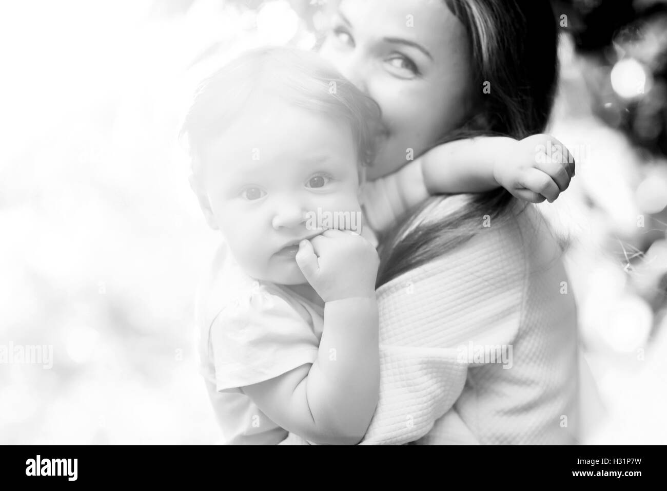 Portrait of a mother holding  child on  sunny day. Black and white Stock Photo