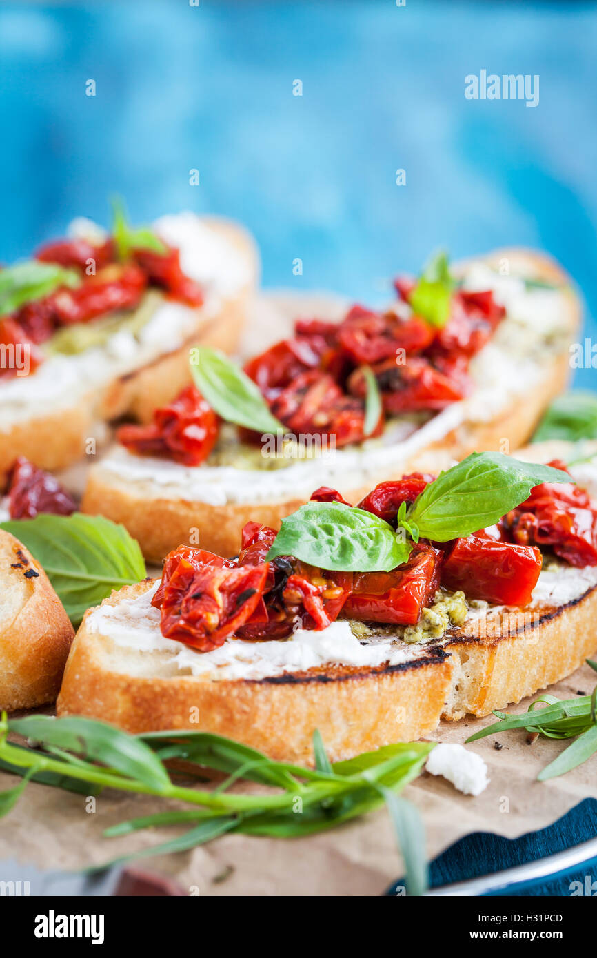 Bruschetta with cream cheese, pesto, fresh basil and sun dried tomatoes