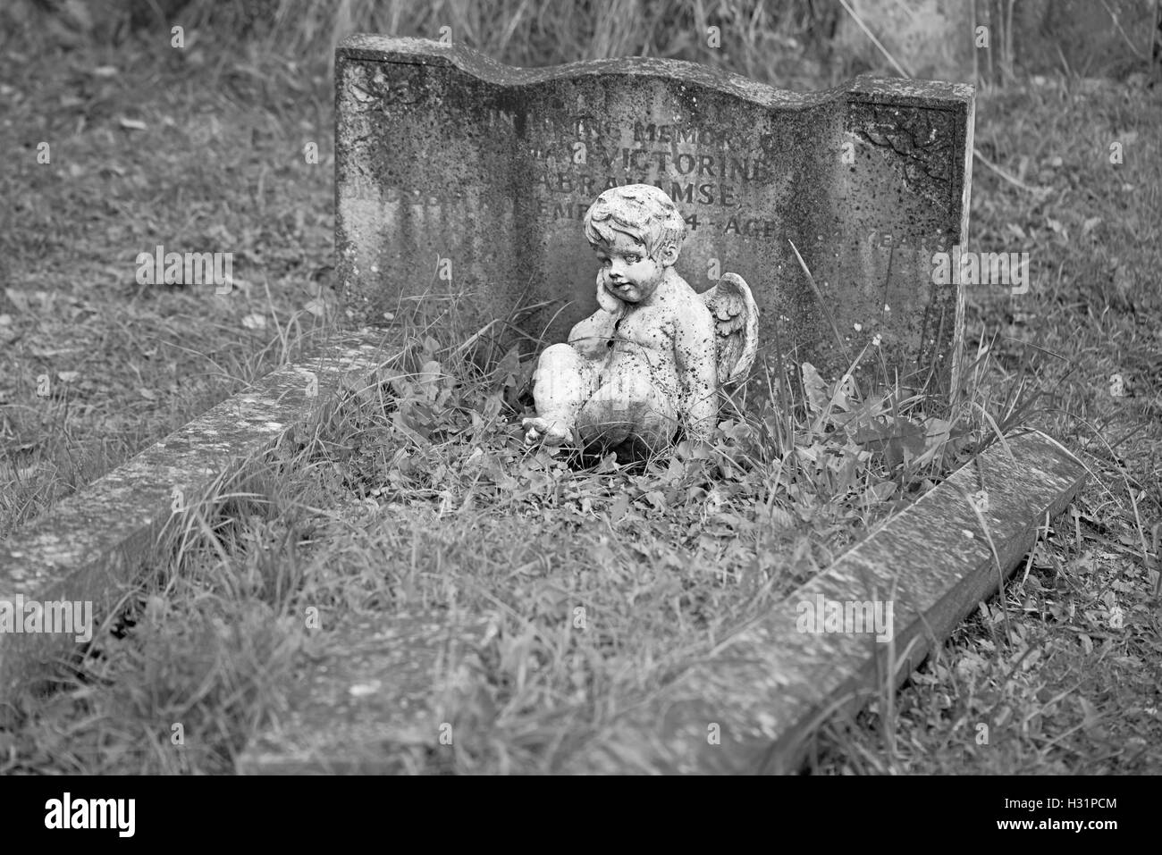 Baby little angel statue ad child's grave at Highgate Cemetery East in London, England. Stock Photo