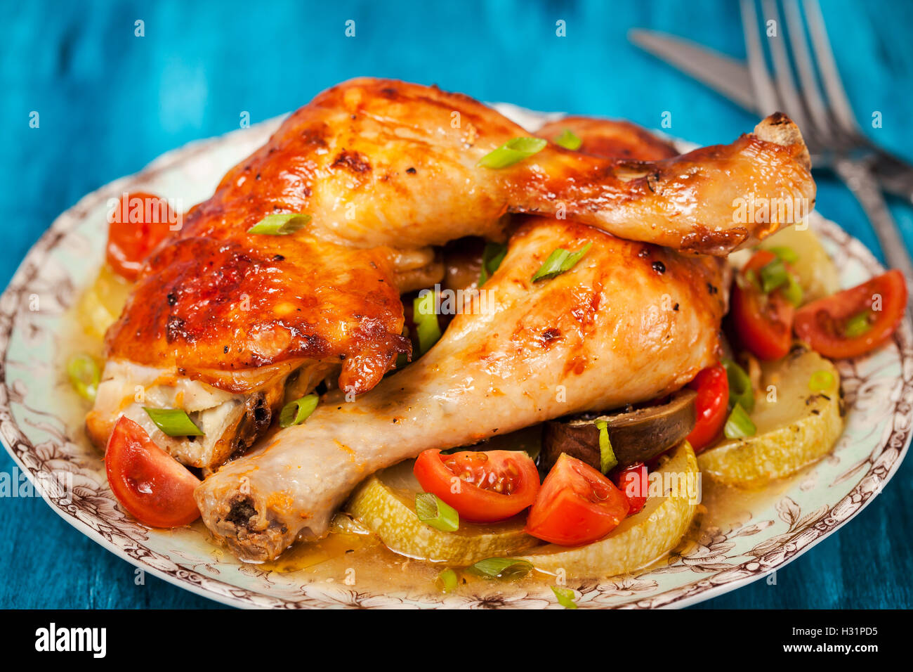 Oven roasted chicken legs with vegetables, ready to eat Stock Photo