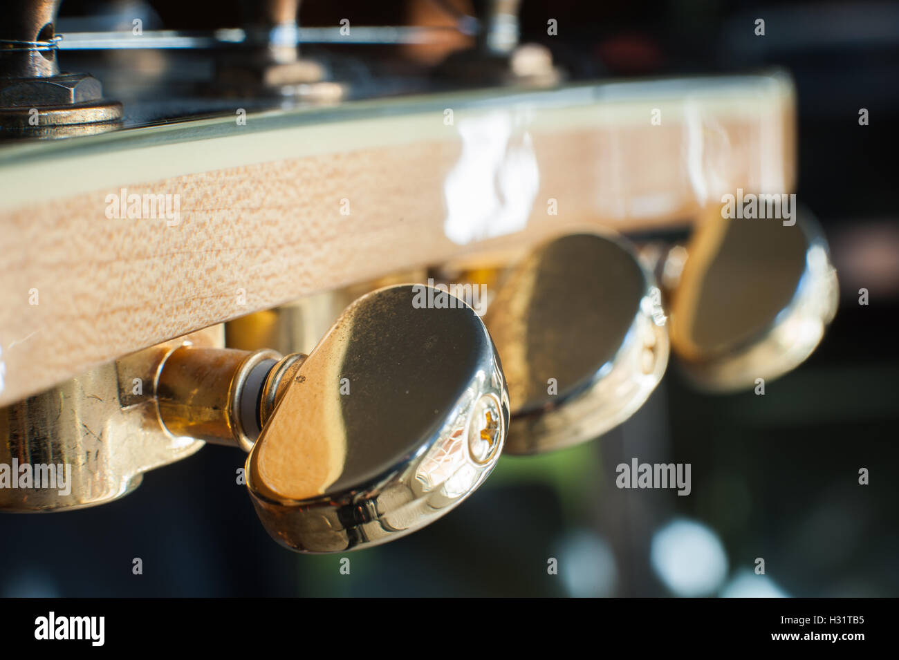 Electric guitar headstock and tuning pegs detail with light effect, selective focus Stock Photo