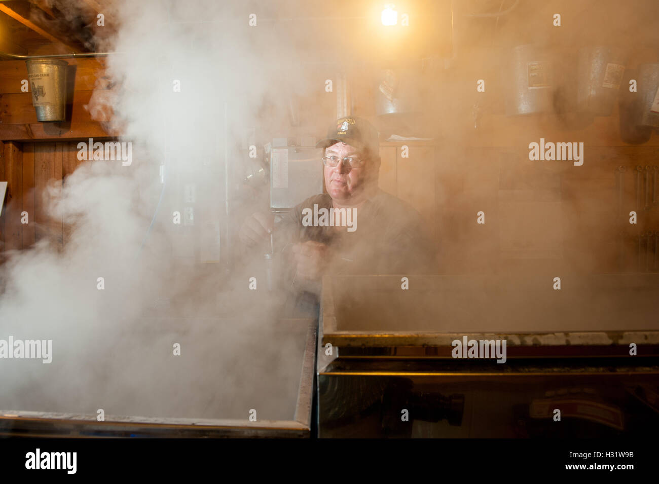 Man checking maple syrup evaporator in Gorham, Maine Stock Photo Alamy