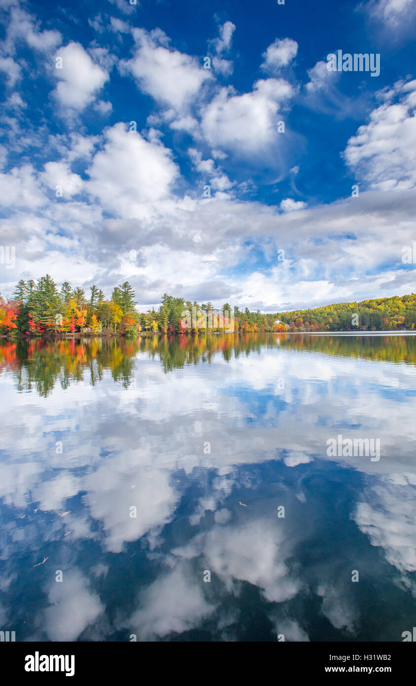 Reflections of the sky and fall foliage on Bryant Pond in Maine. Stock Photo