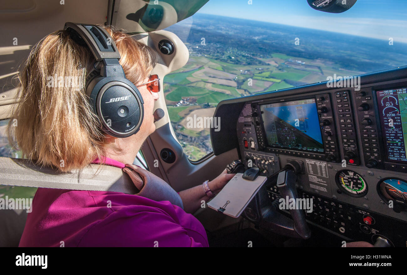 Female pilot in a cockpit flying an airplane over Frederick, Maryland Stock Photo