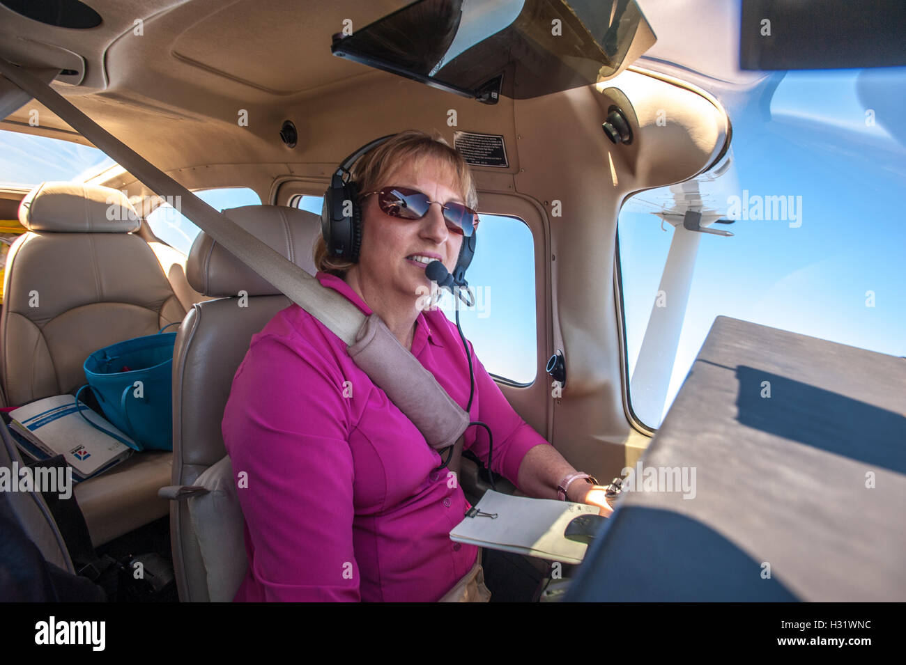 Female pilot in a cockpit flying an airplane over Frederick, Maryland Stock Photo